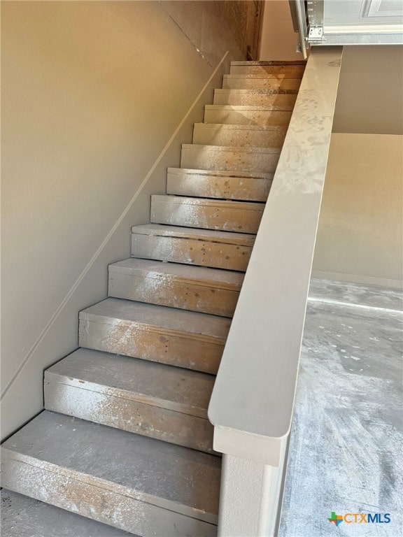 stairway with concrete flooring