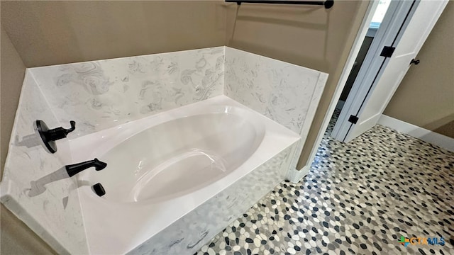 bathroom with a tub to relax in and tile patterned flooring