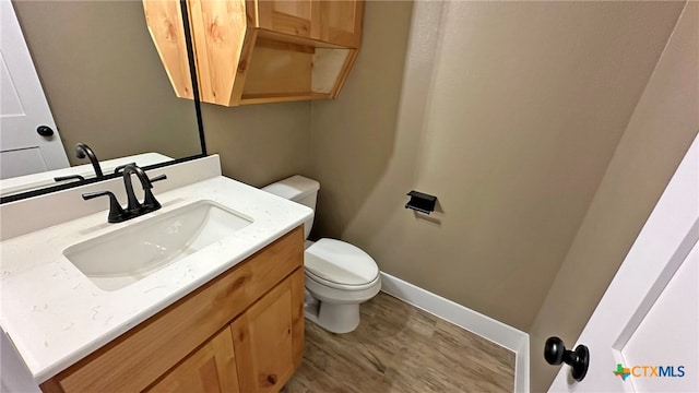 bathroom with toilet, vanity, and hardwood / wood-style floors