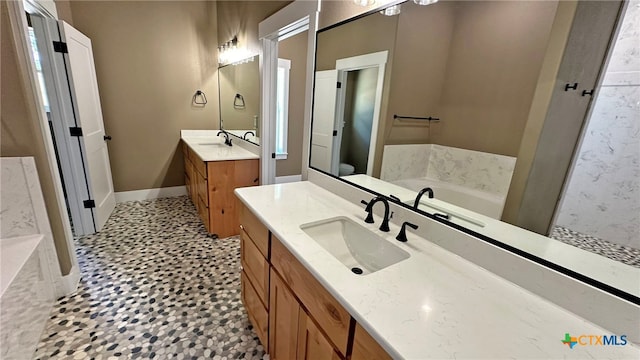 bathroom featuring toilet, tile patterned flooring, vanity, and a tub