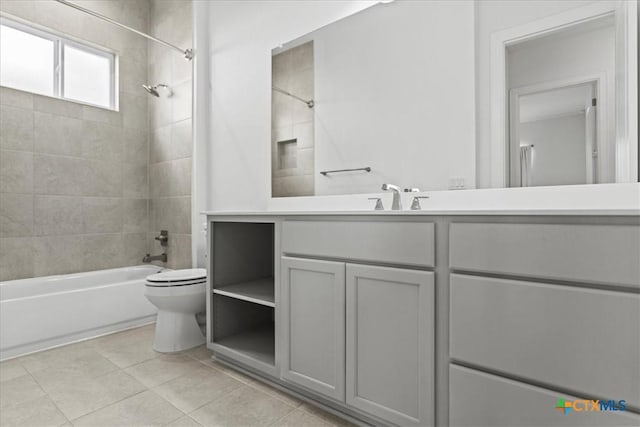 full bathroom featuring tiled shower / bath, vanity, toilet, and tile patterned flooring