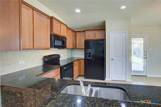 775 Spectrum Dr, New Braunfels, TX 78130 - kitchen featuring black appliances, brown cabinetry, backsplash, dark stone countertops, and recessed lighting