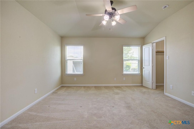 775 Spectrum Dr, New Braunfels, TX 78130 - unfurnished bedroom with vaulted ceiling, multiple windows, light colored carpet, a spacious closet, and ceiling fan