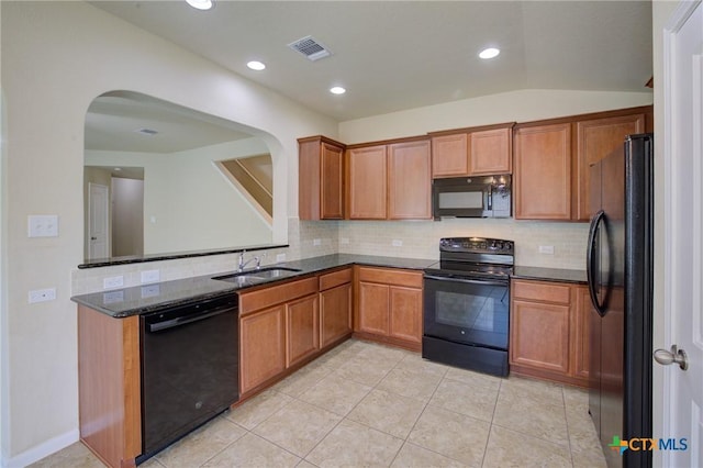 775 Spectrum Dr, New Braunfels, TX 78130 - kitchen with black appliances, arched walkways, tasteful backsplash, dark stone counters, and recessed lighting