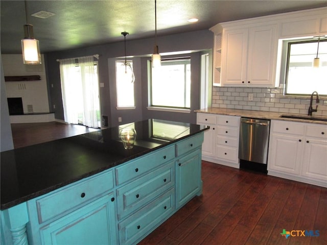 kitchen featuring dishwasher, sink, pendant lighting, and white cabinets