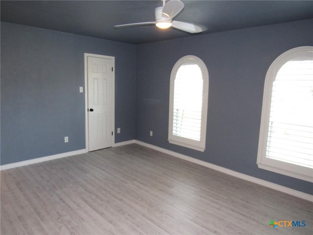 spare room with ceiling fan and light wood-type flooring