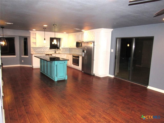 kitchen featuring a kitchen island, appliances with stainless steel finishes, pendant lighting, white cabinetry, and dark wood-type flooring