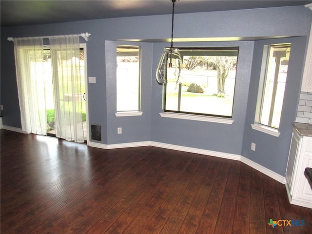 unfurnished dining area featuring dark hardwood / wood-style flooring and a wealth of natural light