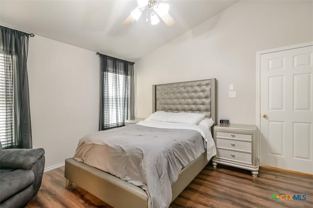 bedroom with dark wood-style floors, multiple windows, and vaulted ceiling