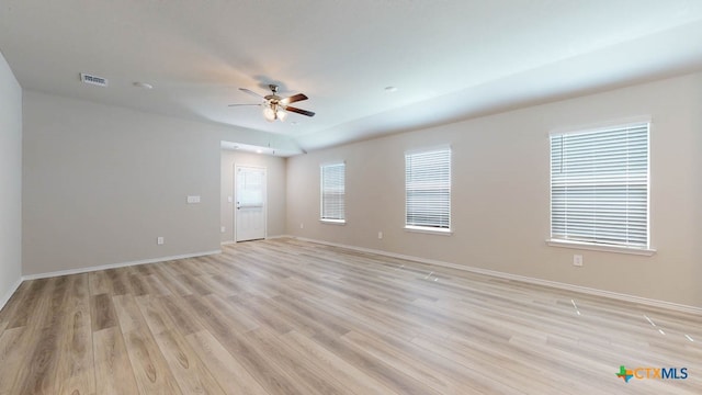 spare room featuring ceiling fan, a healthy amount of sunlight, and light wood-type flooring