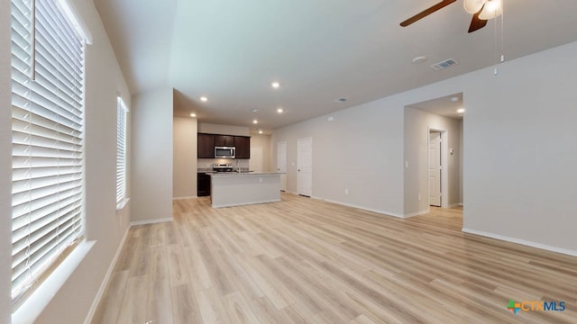 unfurnished living room with light wood-type flooring and ceiling fan