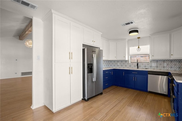 kitchen with appliances with stainless steel finishes, white cabinets, blue cabinets, and sink