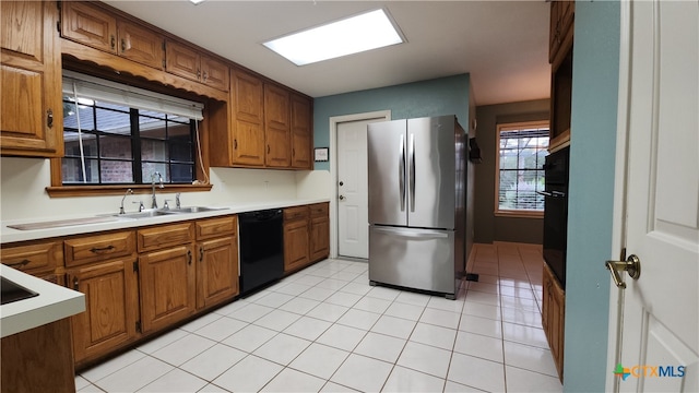 kitchen featuring light tile patterned flooring, sink, and black appliances