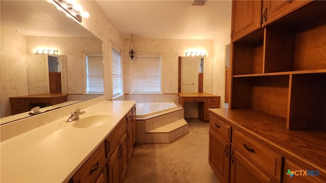 bathroom featuring concrete flooring, vanity, and tiled tub