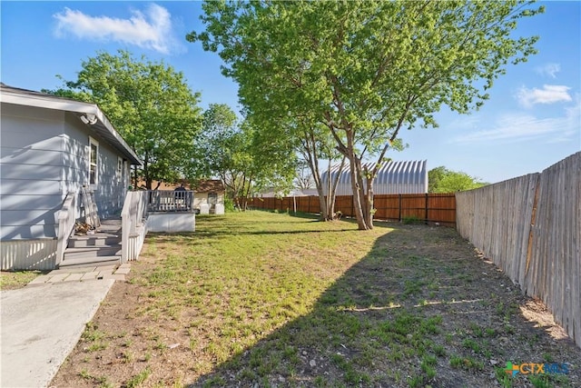 view of yard with a wooden deck and a fenced backyard