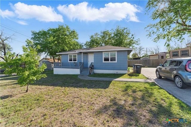 bungalow-style home featuring fence and a front lawn