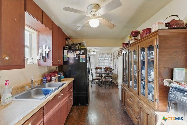 kitchen with dark wood-style floors, a sink, ceiling fan, light countertops, and freestanding refrigerator