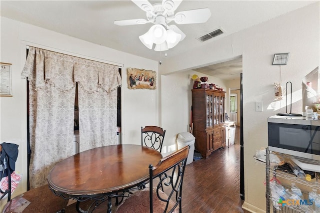 dining area with a ceiling fan, visible vents, and wood finished floors