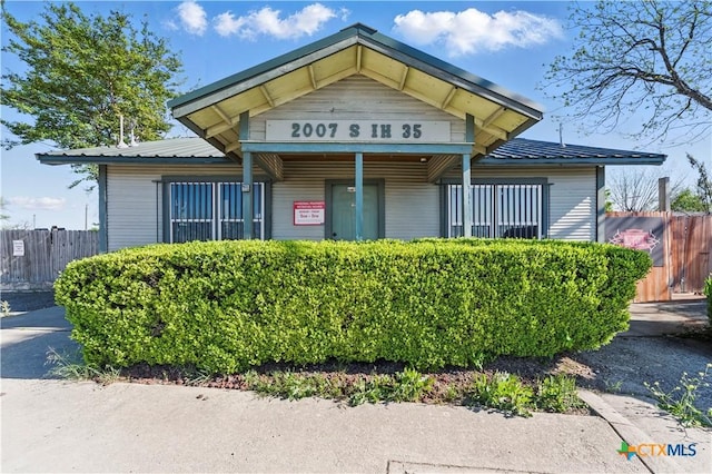 view of front of property with fence and metal roof