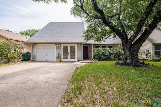 7503 Islander Dr, Austin, TX 78749 - view of front of house featuring an attached garage, french doors, driveway, roof with shingles, and a front yard