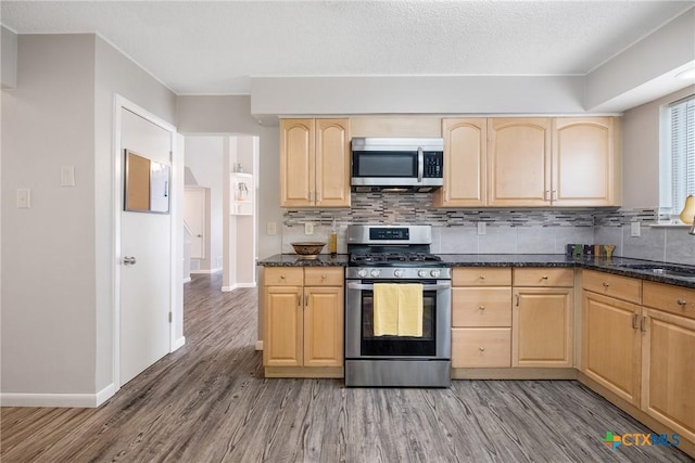 7503 Islander Dr, Austin, TX 78749 - kitchen featuring appliances with stainless steel finishes, light brown cabinets, light wood-type flooring, baseboards, and a textured ceiling