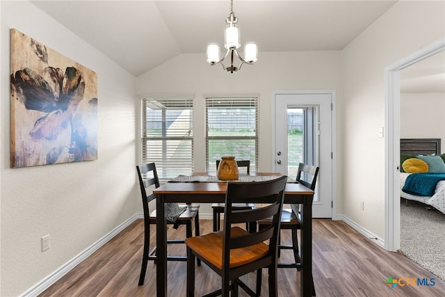 dining space with wood-type flooring, an inviting chandelier, and lofted ceiling