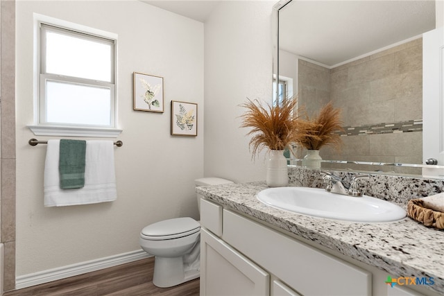 bathroom with toilet, vanity, and hardwood / wood-style floors