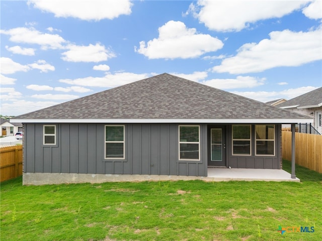 back of house featuring a lawn and a patio area