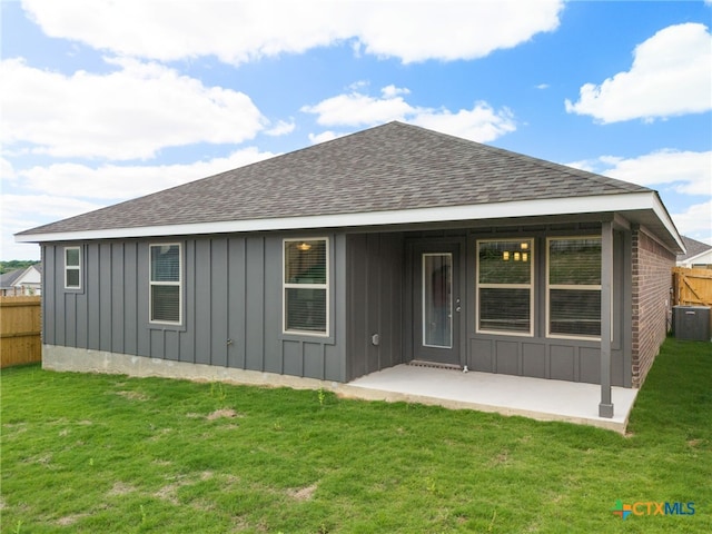 rear view of property with central AC, a patio area, and a yard