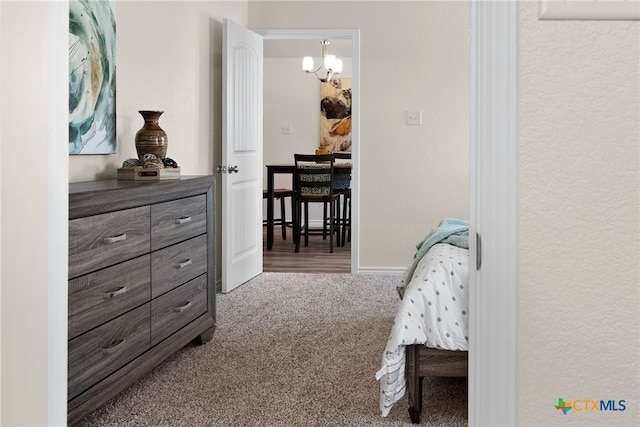 bedroom with carpet flooring and a notable chandelier