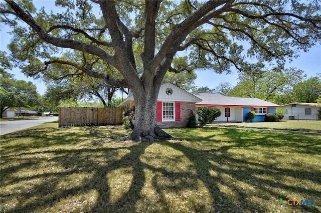 view of front facade featuring a front lawn and fence