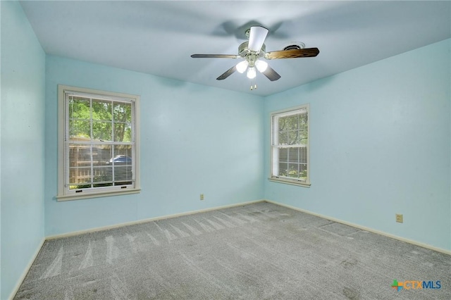 empty room with a ceiling fan, baseboards, and carpet