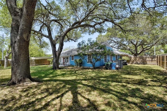 rear view of house featuring a yard and a fenced backyard