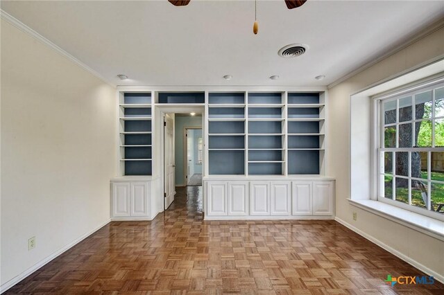 empty room featuring ornamental molding, visible vents, built in features, and baseboards