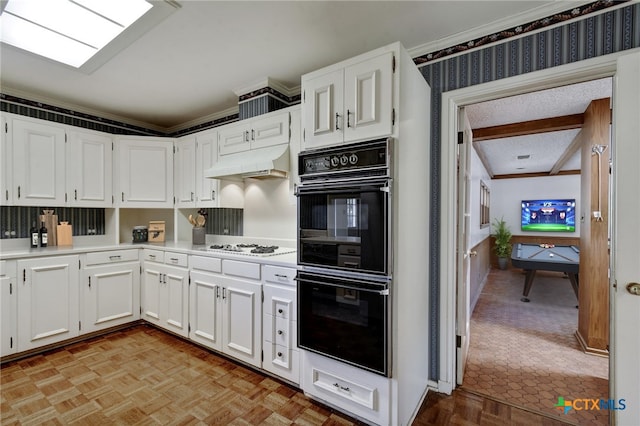 kitchen with dobule oven black, ornamental molding, and under cabinet range hood