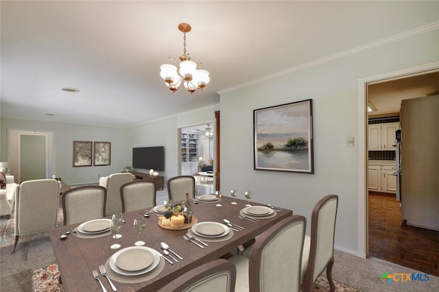 dining space with crown molding, baseboards, carpet flooring, and a notable chandelier