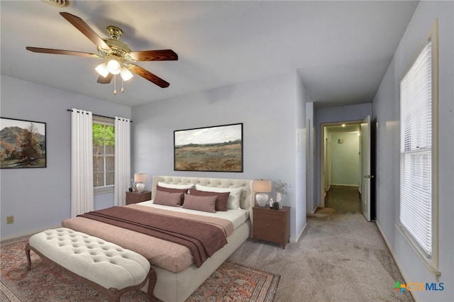 bedroom with light carpet and a ceiling fan