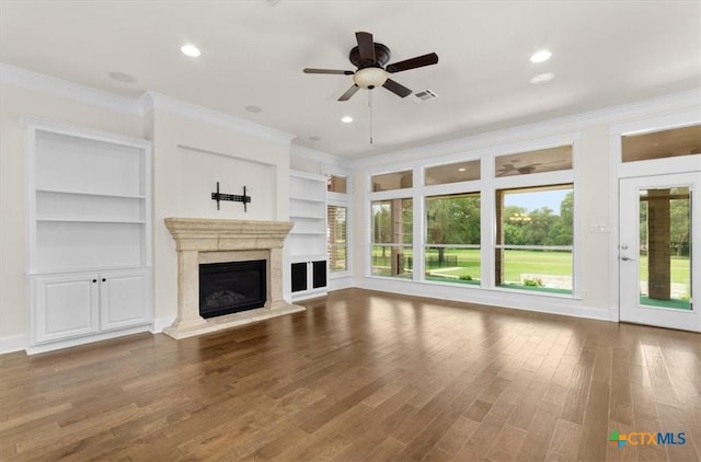 2901 Chisholm Trl, Salado, TX 76571 - unfurnished living room featuring crown molding, ceiling fan, built in shelves, wood finished floors, and a premium fireplace