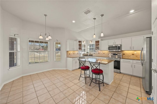 kitchen with white cabinets, stainless steel appliances, and pendant lighting