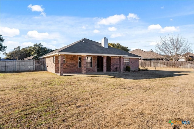 back of house featuring a patio area and a yard