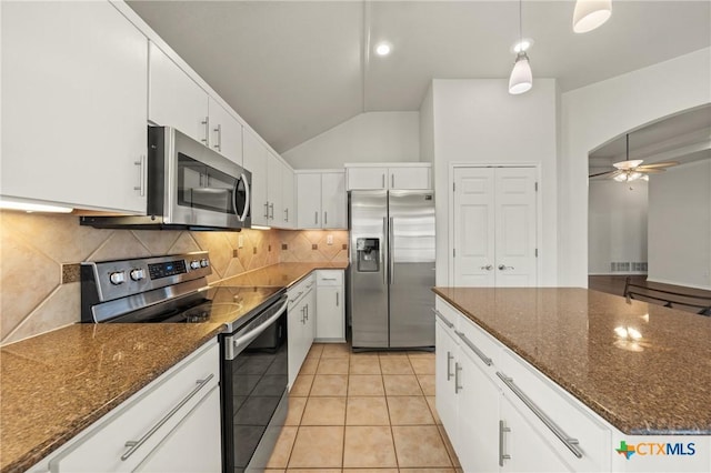 kitchen featuring ceiling fan, vaulted ceiling, light tile patterned floors, stainless steel appliances, and white cabinets