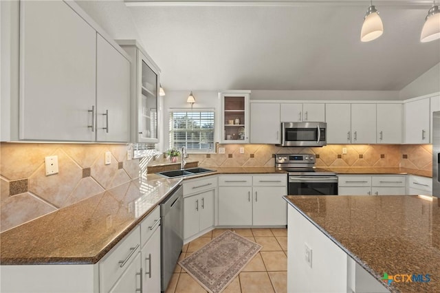 kitchen with appliances with stainless steel finishes, backsplash, decorative light fixtures, white cabinets, and sink