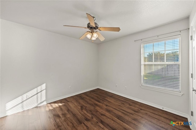 empty room with ceiling fan and dark hardwood / wood-style flooring