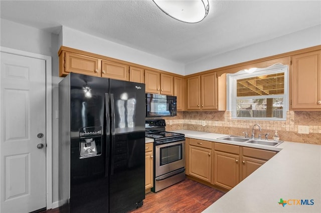 kitchen with dark wood-style flooring, a sink, black appliances, light countertops, and backsplash