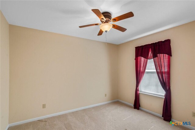 unfurnished room with baseboards, light colored carpet, and a ceiling fan