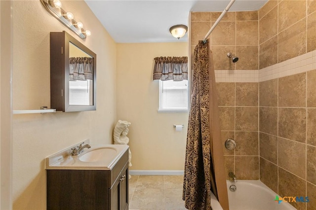 bathroom with a wealth of natural light, shower / bath combo with shower curtain, vanity, and baseboards