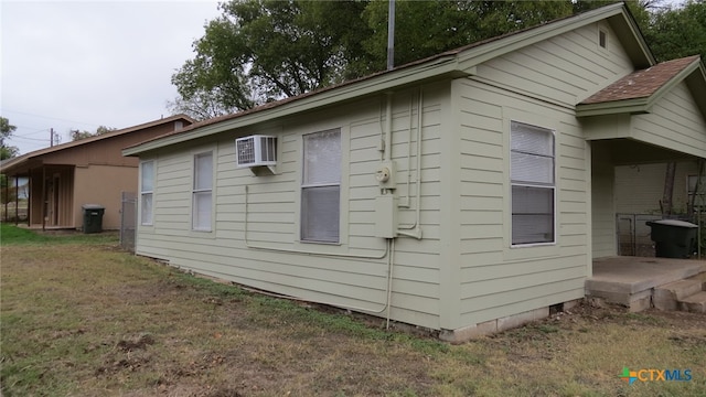 view of home's exterior with a yard and a wall mounted air conditioner