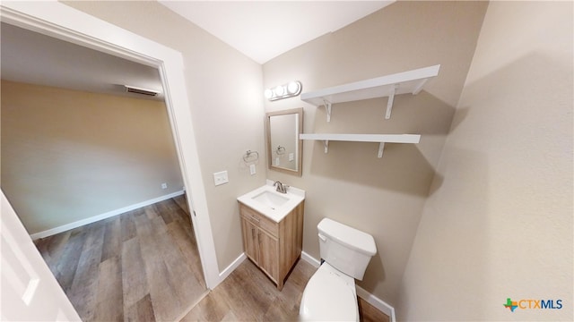 bathroom with hardwood / wood-style floors, vanity, and toilet