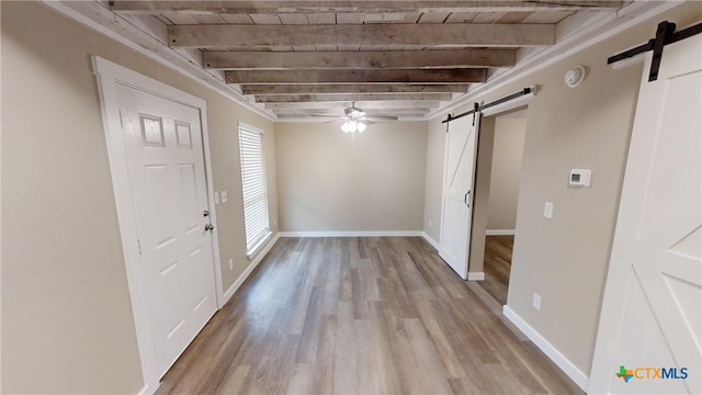 foyer entrance featuring wood ceiling, a barn door, ceiling fan, beam ceiling, and light hardwood / wood-style flooring