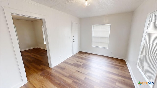 unfurnished bedroom with light hardwood / wood-style floors, a textured ceiling, and a closet